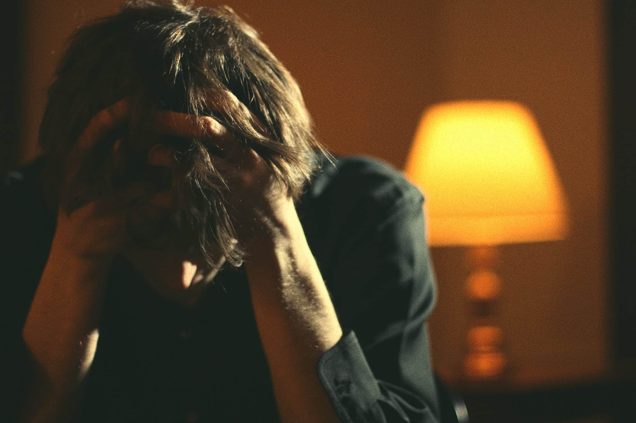 Man with head in hands looking frustrated