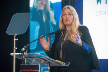 Sacha Dench standing at the podium delivering a talk