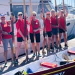 Gig rowers standing on the pontoon next to their gig all holding their oars