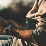 man sitting outside holding an ipad in his hands