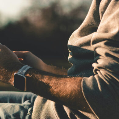 man sitting outside holding an ipad in his hands