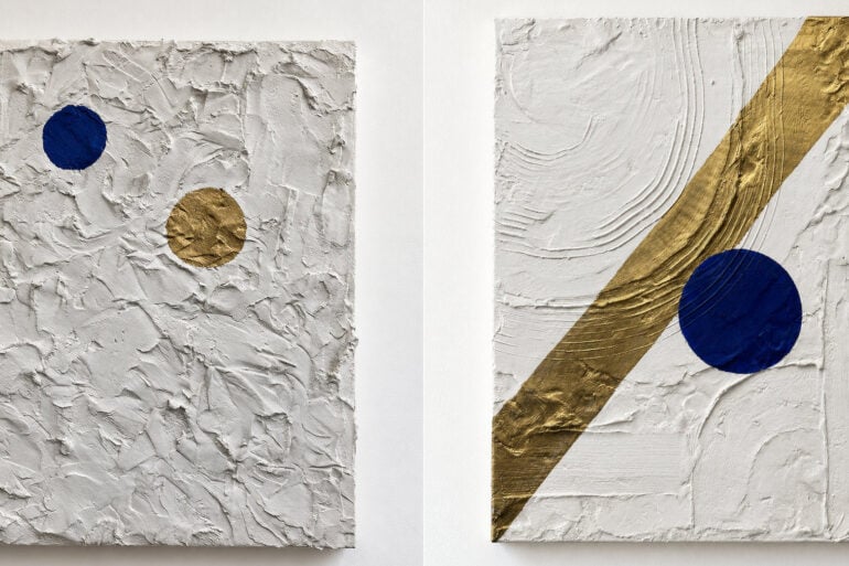 Two paintings side by side - White plaster on canvas with a dark blue circle and a gold circle aligning and White painting with a blue circle on it and gold line running from top to bottom