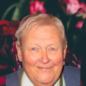 Bouquet of flowers on a dark background with photo of Ken Matthews on top