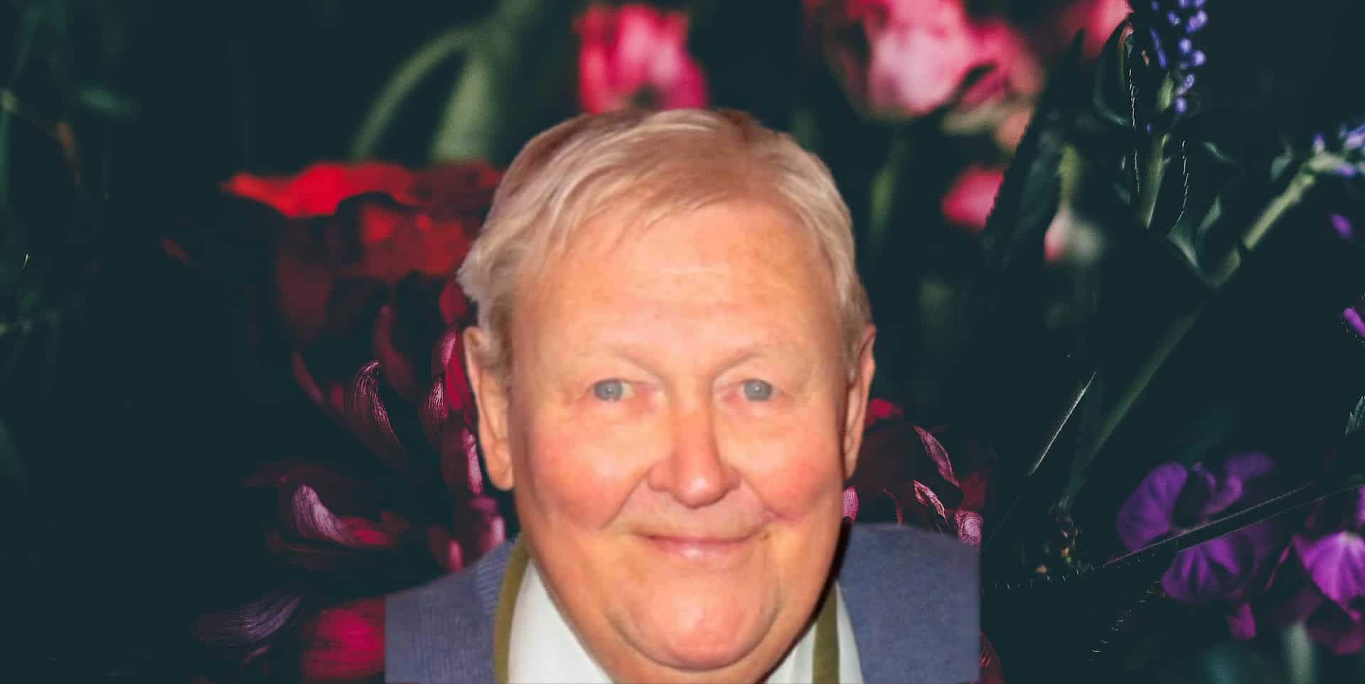 Bouquet of flowers on a dark background with photo of Ken Matthews on top