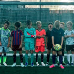 boys in football kit standing in line across the goal