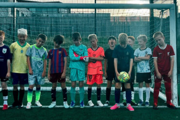 boys in football kit standing in line across the goal