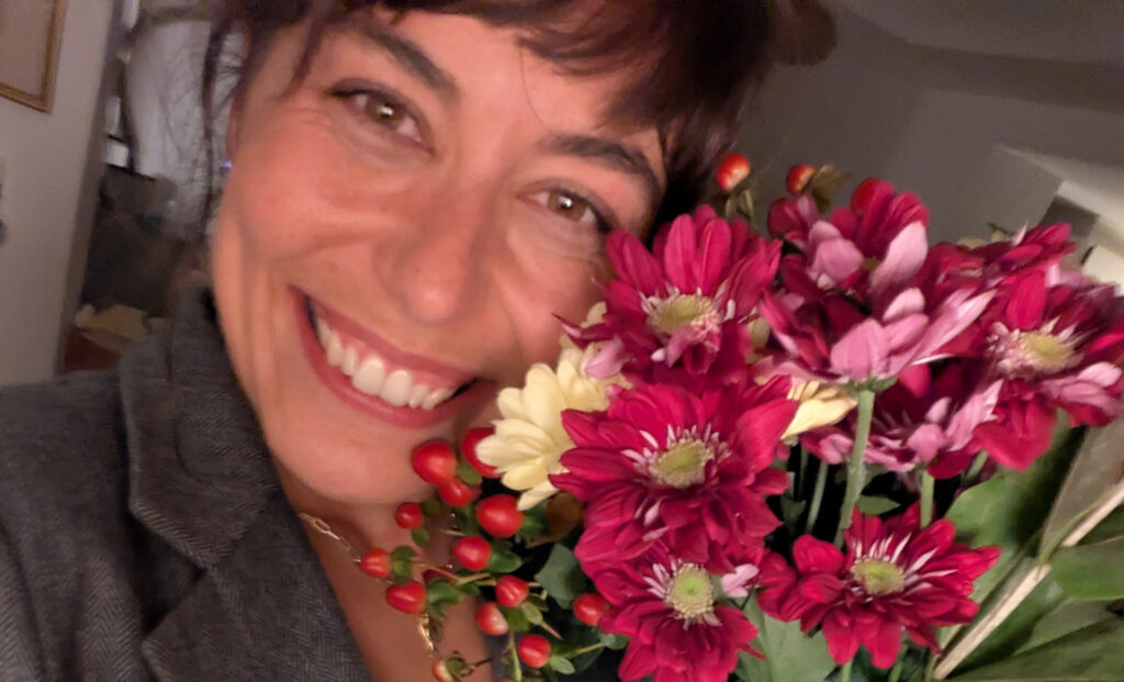 Sarah Nicole holding a bouquet of flowers near her face