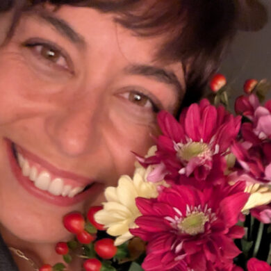 Sarah Nicole holding a bouquet of flowers near her face