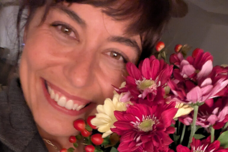 Sarah Nicole holding a bouquet of flowers near her face