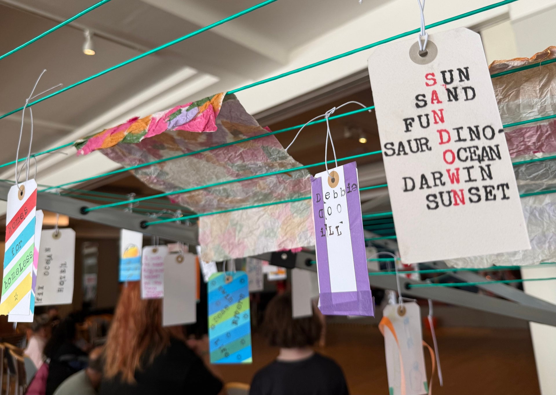 Messages of support for Sandown written on luggage labels hanging on a washing line