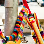 bicycle by a lamp post that has been covered in knitting