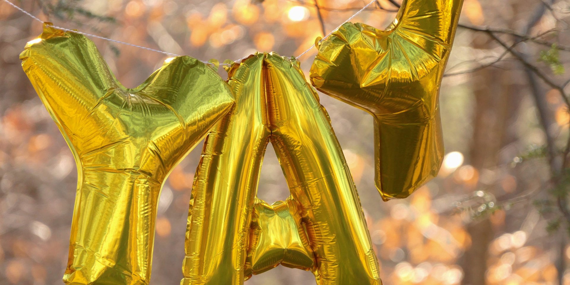 gold letter balloons spelling YAY
