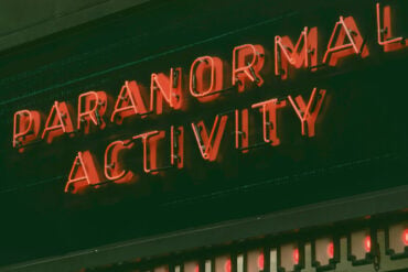 neon sign reading paranormal activity