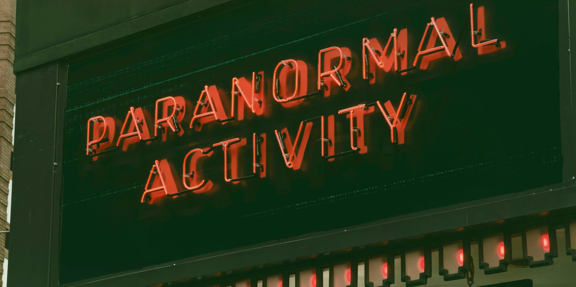 neon sign reading paranormal activity