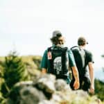 two men trekking on a hillside