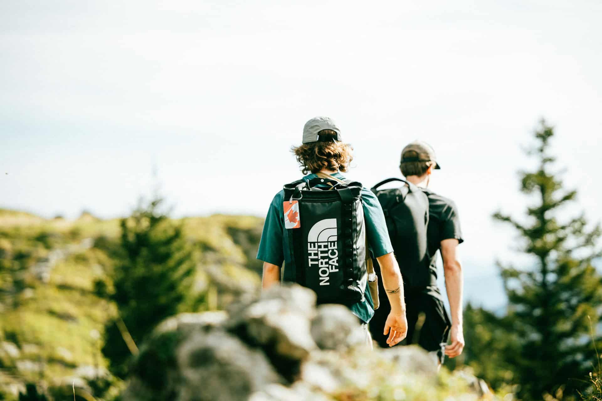 two men trekking on a hillside